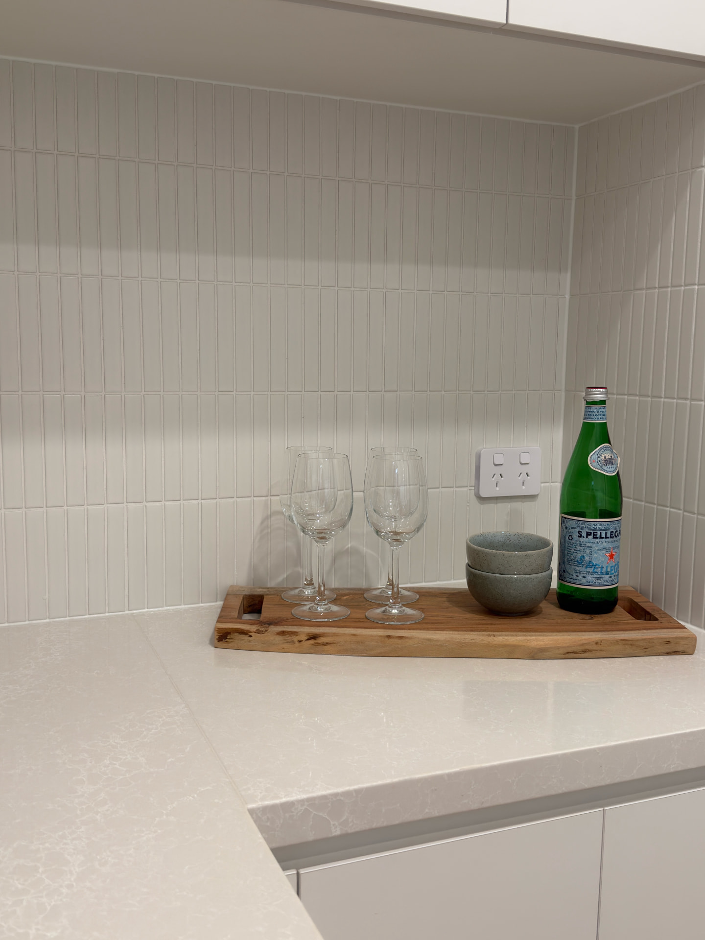 Close-up of a stone kitchen benchtop and tiled splashback